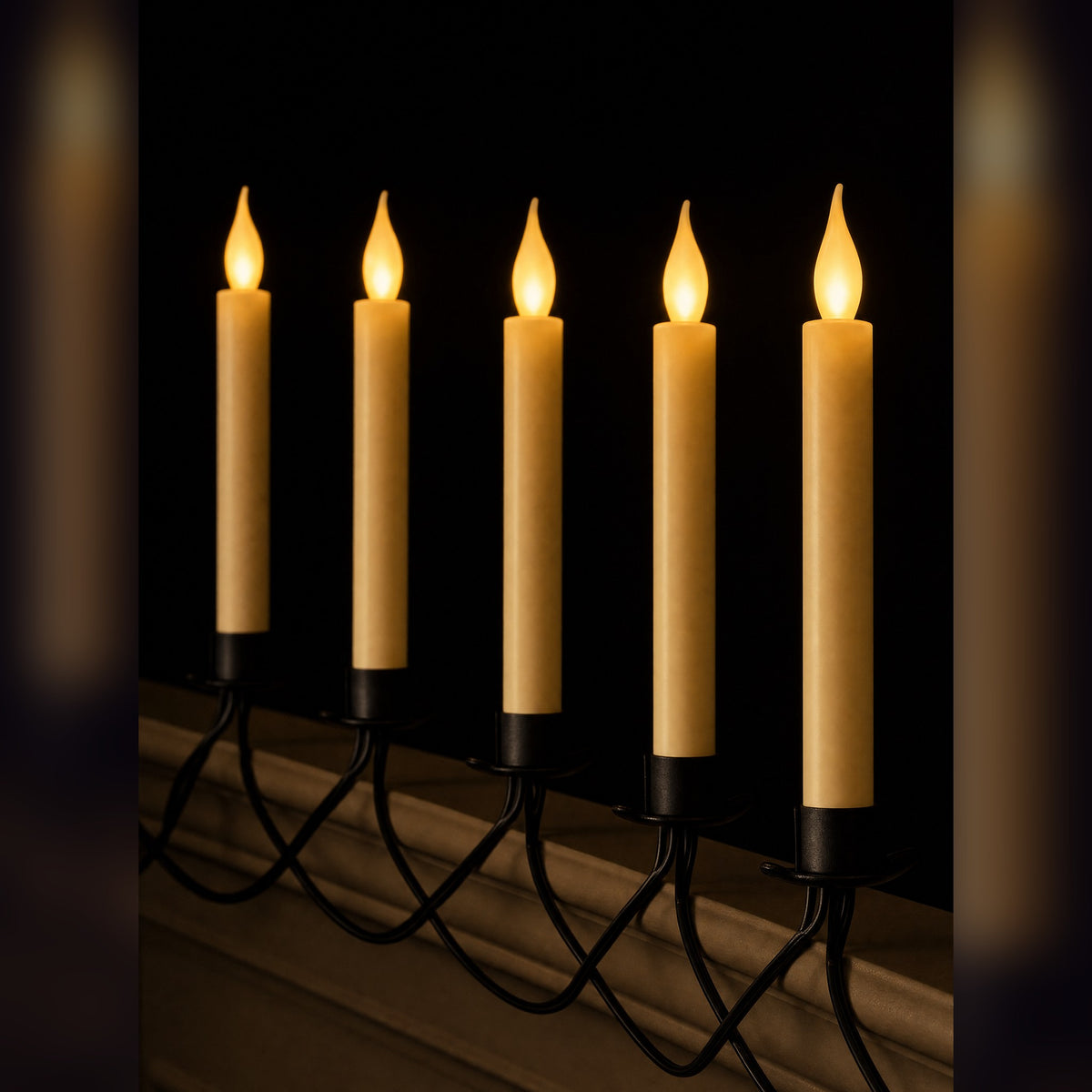 Ember Row flameless candles lit along a dark ledge, warm flickering flames on a black wire vine