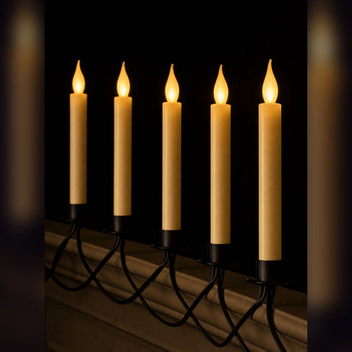 Ember Row flameless candles lit along a dark ledge, warm flickering flames on a black wire vine