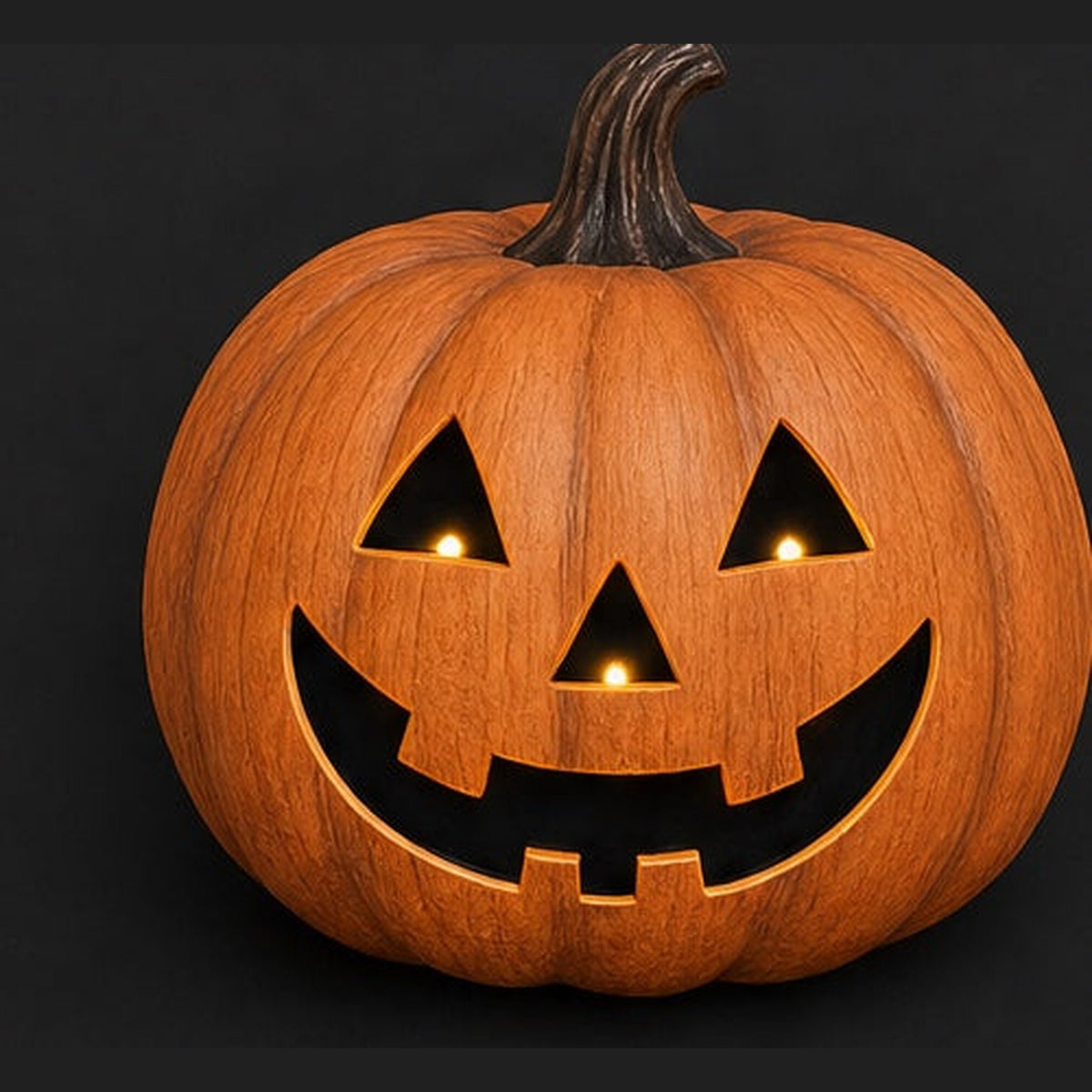 Carved jack-o-lantern with a wide friendly grin lit warmly from inside