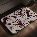 Plush doormat printed with dark crimson handprints, footprints and splatter, laid on a wooden floor by a panelled door