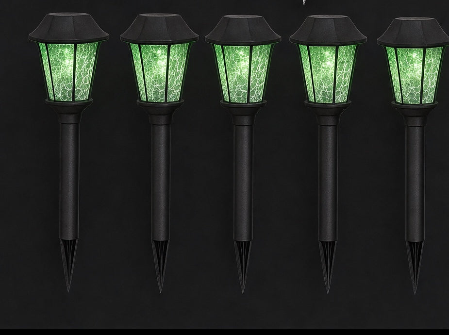 Five black garden stakes topped with lanterns glowing acid green in the dark
